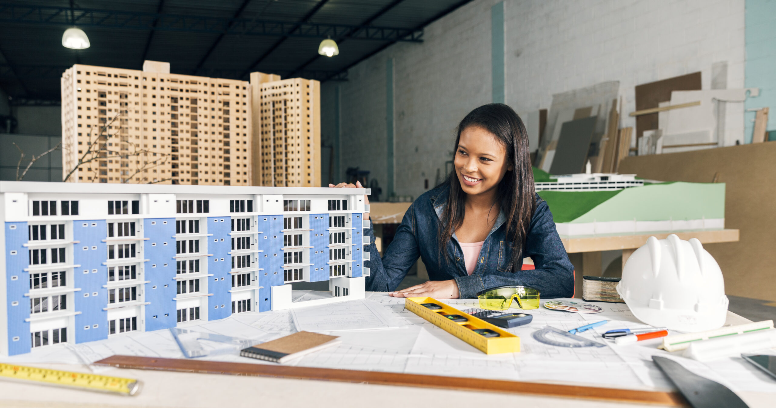 smiling-african-american-woman-near-model-building-table-with-equipments
